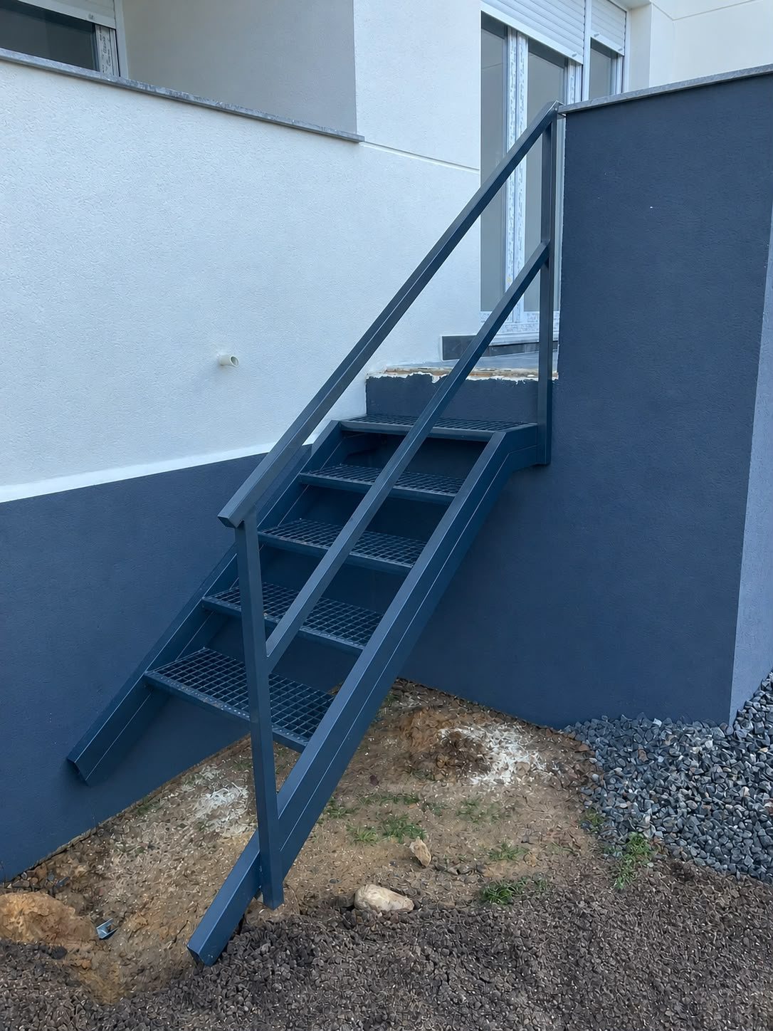 Escalera metálica exterior con peldaños de rejilla